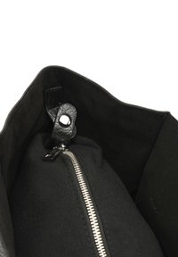 Sac à main noir avec un extérieur en cuir texturé. L'intérieur est doublé de tissu noir et comprend un compartiment zippé avec des accessoires en argent.