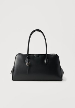 Sac à main en cuir noir avec un design structuré, des anses arrondies et un porte-clés amovible arborant un motif géométrique. Texture lisse, intérieur spacieux.