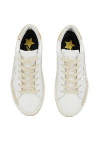 Zapatillas blancas con cordones beige. Material de cuero suave, puntera redondeada y diseño de estrella en el costado. Acentos dorados en la lengüeta y el logo.