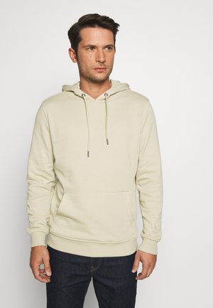 Beige hettegenser med en frontlomme, justerbare snorer, ribbede mansjetter og hem, laget av myk, teksturert stoff.