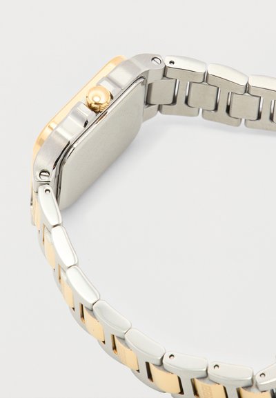 Ρολόι χειρός με τετράγωνο καντράν και μπρασελέ από μεταλλικούς κρίκους σε δύο αποχρώσεις, με χρυσό κορωνάκι στο πλάι, απεικονισμένο από πίσω.