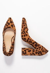 Lodičky s leopardím potiskem a špičatou špičkou, vyrobené z měkkého semiše. Mají robustní blokový podpatek pro stabilitu a hladký béžový interiér.