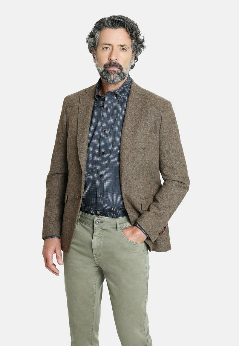 Blazer de mezcla de lana marrón, camisa azul marino con puntos blancos, pantalones verde claro y un acabado texturizado, con cuello de muesca y detalles en los bolsillos.