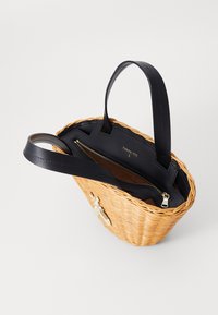 Tkaný proutěný kabelka v hnědé barvě s černými koženými rukojeťmi. Obsahuje zipovou přihrádku a akcenty zlaté barvy. Design s otevřeným vrchem.