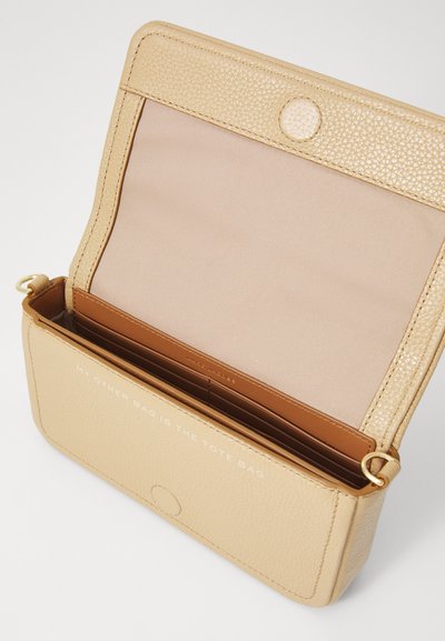 Beige leather crossbody bag open to show fabric lining and multiple card slots, with gold-tone hardware and magnetic snap closure.