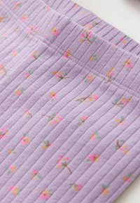 Płócienna tkanina w kolorze lawendowym z wzorem o prążkowanej fakturze, zdobiona drobnymi kwiatowymi motywami w różu, żółci i zieleni. Miękki i lekki materiał.