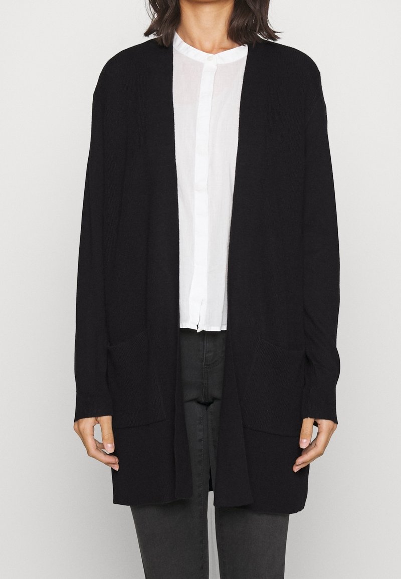 Svart stickad cardigan med öppen front, långa ärmar och två framfickor; texturen är ribbad med en avslappnad passform.