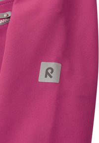Le tissu fuchsia présente un logo argenté sur un patch carré. Le design est lisse, mettant en valeur une texture uniforme sans motifs ni matériel visible.