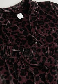 Tumedat lillakujundusega pidžaama komplekt, mustade laikudega. Omab pehmet sametjat tekstuuri, nuppude sulgemist ja nööriga vööosa.