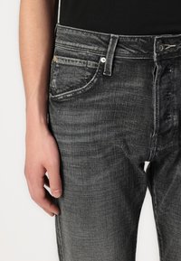 Grijze denim jeans met een slim fit, voorzien van subtiele wassing, vijf-pocket ontwerp en een zilveren hardware accent op de knop.