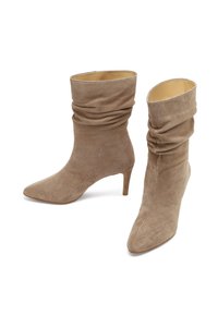 Stivaletti in suede beige con un design morbido, punta appuntita e tacco a cono di 3 pollici. Texture liscia con foderatura interna.
