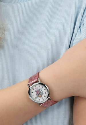 Kinderhandgelenk mit einer silbernen runden Uhr mit einem pink glitzernden Armband und einer bunten Charakterillustration auf dem weißen Zifferblatt.