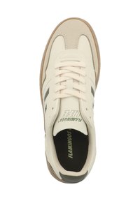 Helles beigefarbenes Sneaker mit dunkelgrünen und schwarzen Streifen, mit Schnürverschluss und brauner Gummisohle. Logo auf der Zunge sichtbar.