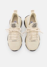 Sneakers atletiche beige con una tomaia in mesh testurizzato, design leggero, lacci color crema e suola in gomma nera. Logo sulla linguetta e sul tallone.