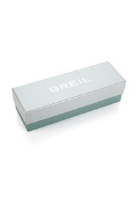 Boîte cadeau rectangulaire de marque Breil ; dessus gris clair avec finition argentée, fond teal, texture lisse, dimensions adaptées pour des bijoux ou des accessoires.