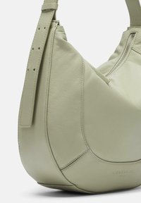 Torba typu hobo w jasnozielonej, miękkiej skórze, o zakrzywionym kształcie, teksturowanej powierzchni i kieszeni na zamek błyskawiczny. Wyposażona w regulowany pasek na ramię.