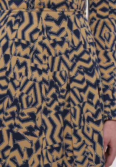 Puuvillane kleit, millel on geometriline print tumesinise ja beeži värviga. Kujundus sisaldab zikk-zakki ja teemantikujundeid koos nähtava õmblemisega.