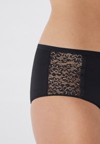 Schwarze Hipster-Unterwäsche mit einem Spitzenpaneel an der Seite mit floralen Mustern, glattem Stoff und einem Gummibund für Komfort und Passform.