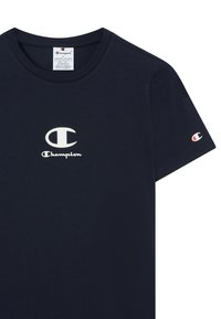 Marineblauwe katoenen t-shirt met een wit "Champion" logo op de borst en een klein logo op de mouw. Ronde halslijn, korte mouwen.