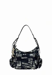 Schoudertas van marineblauwe stof met krantenprint, halfronde vorm, verstelbare riem en geplooide textuur. Detail vanzijrits opzij.