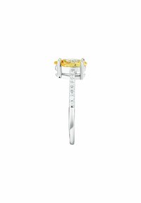 Anello in argento con una grande pietra gialla al centro, accentuato da piccole pietre trasparenti lungo la fascia. Finitura liscia e lucida.