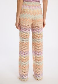 Weite Hose mit einem Zickzackmuster in Pastellfarben, aus strukturiertem Stoff, mit hoher Taille und gewelltem Saum.