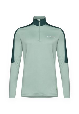 Maglietta a maniche lunghe verde chiaro con zip a un quarto, pannelli delle spalle in verde scuro a contrasto e un piccolo logo sul petto. Tessuto morbido e liscio.