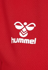 Roter Stoff mit atmungsaktiver Textur, darauf ist ein weißes Logo einer stilisierten Biene und das Wort "hummel" in fetten Buchstaben zu sehen.