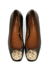 Bailarinas negras con diseño de punta redondeada, que cuentan con un acento dorado texturizado en la puntera. Material de cuero suave con una plantilla en color marrón claro.