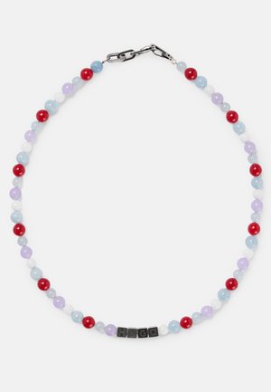 Collier de perles avec des perles alternant en rouge, bleu, violet et blanc, arborant des cubes de lettres noirs formant le mot "HUGO" près d'un fermoir en argent.