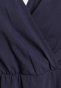 Mörkblå klänning med omslagsdesign, med texturerad tyg och rynkade midjedetaljer. V-ringning och slät finish.