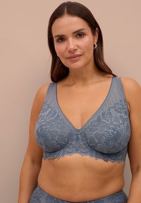 Lace bh in zachte blauwe kleur met een bloemenpatroon, gaasdetails en een V-halsontwerp. Voorzien van brede bandjes en een golvende zoom.