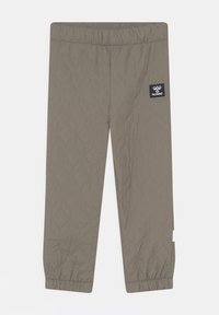 Pikowane jasnobrązowe dziecięce spodnie z elastycznym paskiem w talii i ściągaczami, z czarną naszywką z logo hummel na prawej udzie.