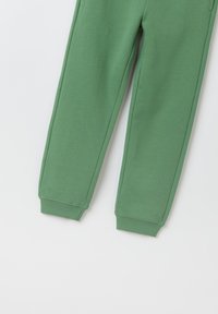 Grüne Baumwoll-Sweatpants mit glattem Material, gerippten Bündchen und Seitennähten. Einfaches Design, keine Muster oder zusätzlichen Akzente.