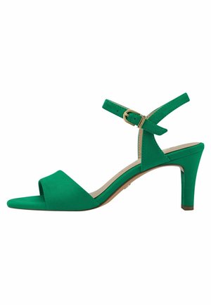 Green suede high-heeled sandal with a v-shaped toe cutout, ankle strap, and gold buckle detail. Stiletto heel with a beige sole.