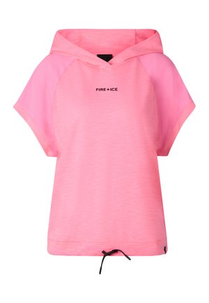 Młoda kobieta z warkoczami, ubrana w różową krótką bluzę z kapturem, czarne legginsy, czarne sandały i duże, refleksyjne okulary przeciwsłoneczne.