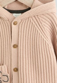 Helles rosa gestricktes Cardigan mit Kapuze. Merkmale sind gerippte Textur, Holzknöpfe und eine Tasche mit besticktem Detail.