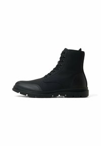 Botas negras hasta el tobillo, hechas de goma con un acabado suave, que cuentan con un cierre de cordones en la parte delantera, un cuello acolchado y una suela texturizada resistente.