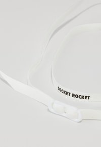 Cinghie flessibili bianche etichettate "SOCKET ROCKET," con una superficie liscia e un design con chiusura per il fissaggio.