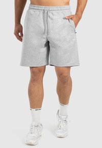 Pantalones cortos de algodón gris con cintura elástica, bolsillos laterales y un pequeño detalle de logo. Presenta un corte relajado y un diseño con dobladillo plano.