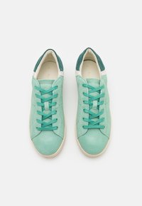 Sneaker in suede verde menta con lacci abbinati, dettagli bianchi sul tallone e superficie testurizzata. Punta arrotondata con forature.