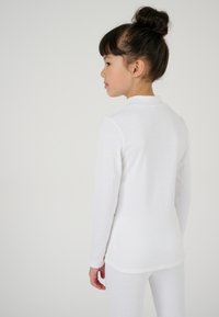 Witte ribbed longsleeve top met een hoge halslijn. Zachte, gestructureerde stof met een aansluitende pasvorm, getoond vanuit de achterkant. Eenvoudig en naadloos ontwerp.