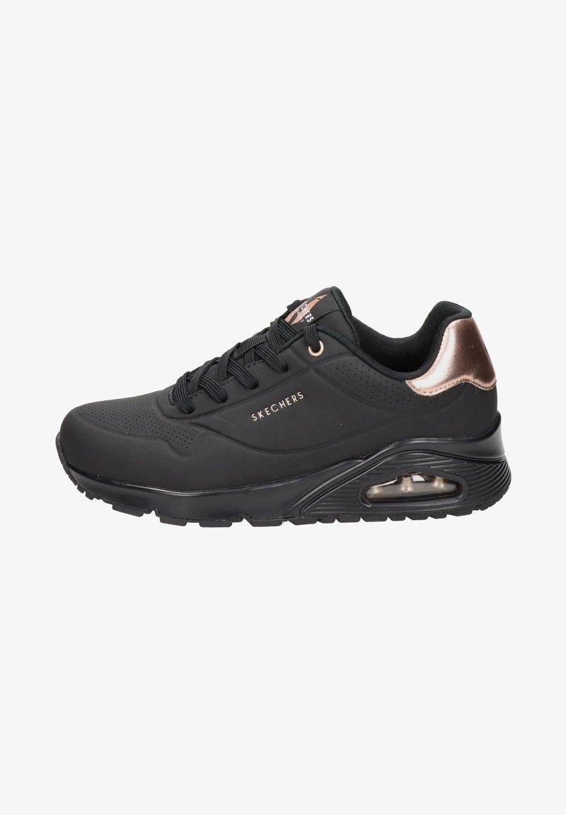 Baskets noires Skechers avec détail métallique en or rose au talon, semelle amortie à coussin d’air, fermeture à lacets à l’avant et tige perforée pour la respirabilité.
