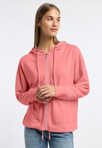 Roze zip-up hoodie van zachte stof met een vo zak, verstelbare trekkoorden en logo-detail op de mouw. Casual pasvorm met een capuchon.