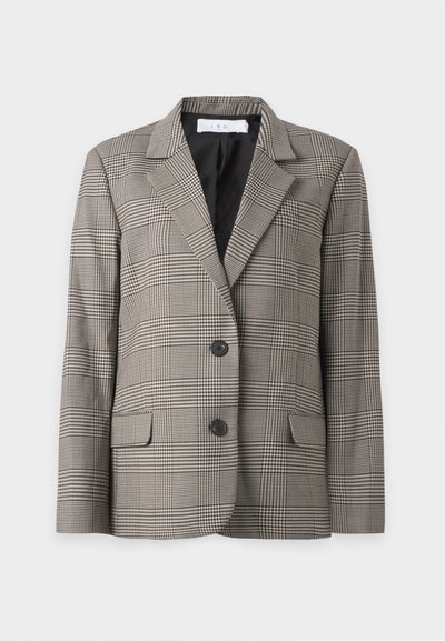 Blazer simple boutonnage avec boutons noirs, motif à carreaux beige et noir, revers crantés et poches à rabat, présenté sur fond blanc.