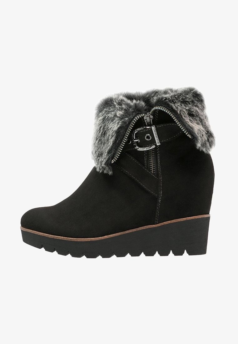 Bottine noire à talon compensé avec bord en fausse fourrure, fermeture éclair latérale et détail boucle décorative.