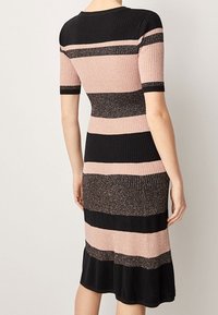 Czarna i różowa w paski, prążkowana sukienka z krótkimi rękawami, z błyszczącymi akcentami i rozkloszowanym dołem. Tekstura wydaje się być dziana i dopasowana.