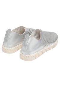 Zapatos slip-on plateados perforados con un upper metálico texturizado, suela de goma blanca contrastante y diseño con ondas en el borde.