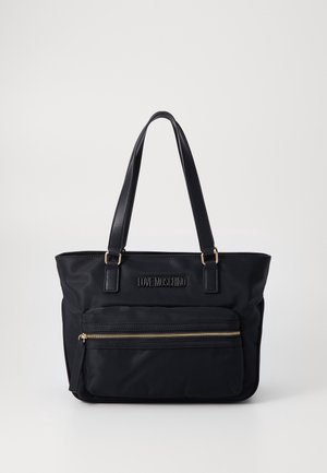 Czarna torba typu tote Moschino z podwójnymi uchwytami i przednią kieszenią na zamek błyskawiczny, złote detale zamka oraz logo na środku z przodu.