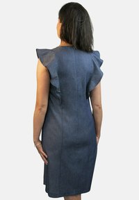 Vestido de mezclilla con mangas estilo cap, diseño ajustado y un sutil detalle de volantes. El color es azul oscuro, con una textura suave y un dobladillo hasta la rodilla.